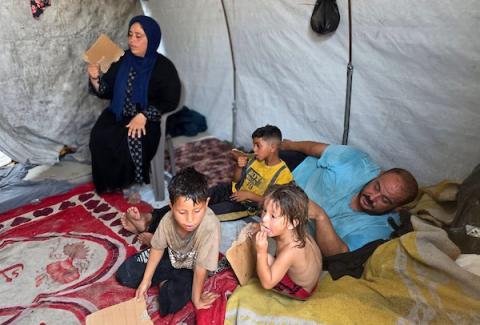 في خيمة بسيطة بمخيم للنازحين في منطقة المواصي بخان يونس، تحاول عائلة الفلسطيني محمد المغير مواصلة تفاصيل حياتها اليومية وسط موجة حر ونقص في الاحتياجات الأساسية، 13 آب/أغسطس 2026. (تصوير: طارق محمد)