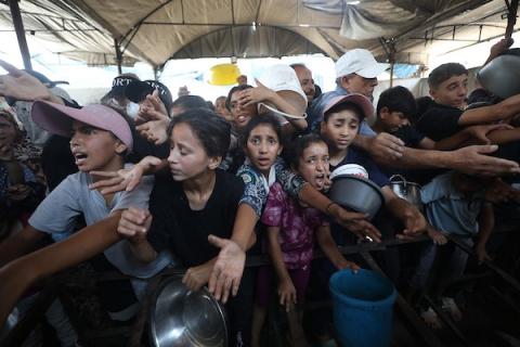 تجمع فلسطينيون نازحون لتلقي وجبات طعام من مطبخ خيري في مخيم النصيرات للاجئين، وسط قطاع غزة، في 16 أغسطس/آب 2026. صورة: حسن الجدي