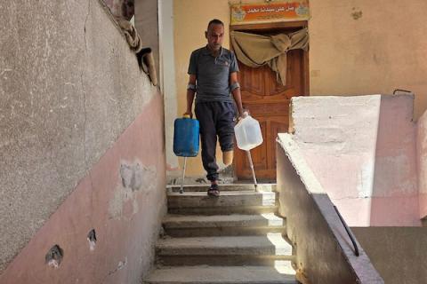 الفلسطيني محمد حسن البرغوث، الذي فقد ساقه خلال الحرب، يقف متكئًا على عكاز في خان يونس، جنوب قطاع غزة، في 12 أغسطس/آب 2026. (صورة: طارق محمد)