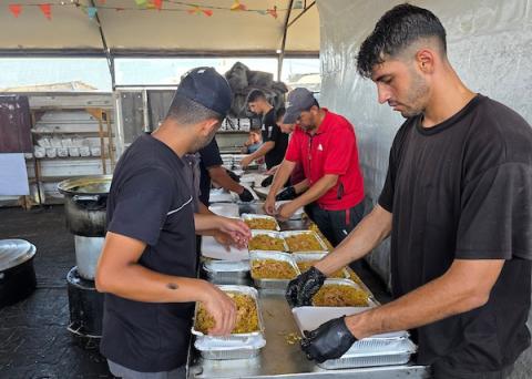 فلسطينيون ينتظرون دورهم للحصول على وجبة من مطبخ خيري في منطقة المواصي بخان يونس، جنوب قطاع غزة، في 7 أغسطس/آب 2026، وسط استمرار الأزمة الإنسانية ونقص الإمدادات الغذائية. تصوير: طارق محمد