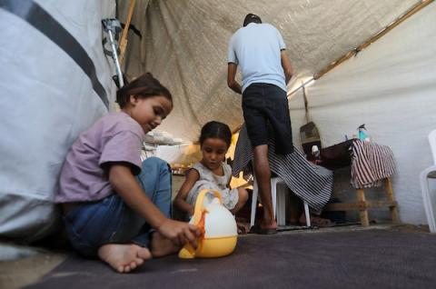 الحلاق الفلسطيني شادي البراوي، 35 عاما، يعمل داخل خيمة نزح إليها مع عائلته في مدينة غزة، في 27 آب/أغسطس 2026، بعدما فقد ساقه اليمنى إثر إصابته بشظايا خلال هجوم إسرائيلي على حي الشيخ رضوان.(تصوير: بلال أسامة)