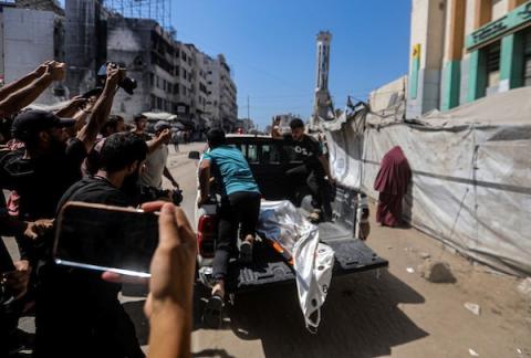 انتشل مسعفون ومتطوعون جثامين شهداء وجرحى من موقع غارة إسرائيلية استهدفت مقرًا للشرطة البلدية وسط  غزة، 19 أغسطس/آب 2026،(صورة: بلال أسامة)