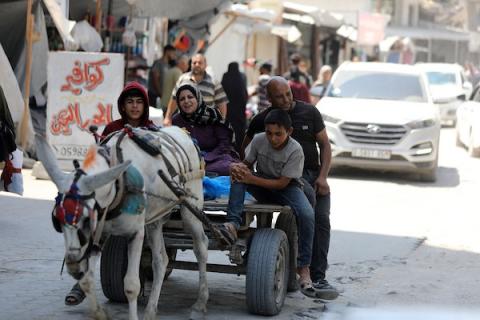 فلسطينيون نازحون يمارسون تفاصيل حياتهم اليومية بين خيام الإيواء والمباني المدمرة في شمال مدينة غزة، في 27 آب/أغسطس 2026. (تصوير: بلال أسامة)