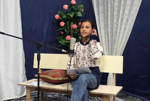 أطفال فلسطينيون يشاركون في إعداد وتقديم برامج لقناة طلائع فلسطين من استوديو متواضع أُقيم داخل خيام النزوح في منطقة مواصي خان يونس. (تصوير: طارق محمد)
