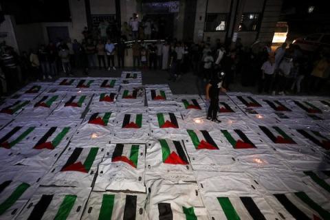 فلسطينيون يشعلون الشموع أمام مستشفى العودة في مخيم النصيرات وسط قطاع غزة، في 28 سبتمبر/أيلول 2026، خلال وداع رفات شهداء انتُشلت من تحت أنقاض المنازل المدمرة، وسط استمرار عمليات البحث والانتشال.  (صورة: معز صالحي)