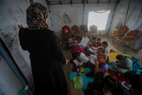 أطفال فلسطينيون يحضرون درساً داخل خيمة تعليمية مؤقتة، جالسين على الأرض في غرب مدينة غزة، في 20 سبتمبر/أيلول 2026.صورة: بلال أسامة