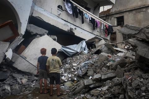 فلسطينيون يتفقدون ممتلكاتهم بين أنقاض مبنى سكني دمره قصف جوي إسرائيلي ليلًا في حي الرمال بمدينة غزة، 11 أكتوبر/تشرين الأول 2026. (تصوير: محمد صالحة)