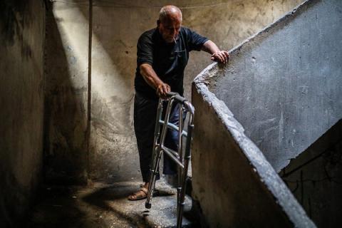 الفلسطيني محمود فؤاد الدهشان (64 عامًا) يستعين بجهاز طبي للمشي في حي الزيتون بمدينة غزة، بعد فقدان قدمه اليسرى في قصف إسرائيلي عام 2023. ويقول إن جنود الاحتلال صادروا طرفه الصناعي أثناء عودته من مصر، في 13 أكتوبر/تشرين الأول 2026. (تصوير: بلال أسامة)