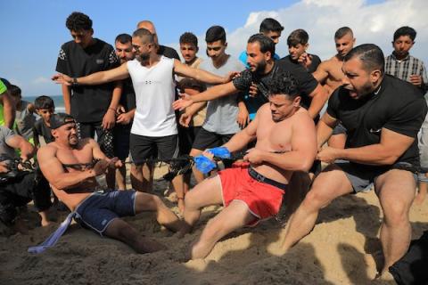 شبان فلسطينيون يمارسون تمارين وأنشطة رياضية على شاطئ النصيرات وسط قطاع غزة، يوم 16 أكتوبر/تشرين الأول 2026. (تصوير: حسن الجدي)