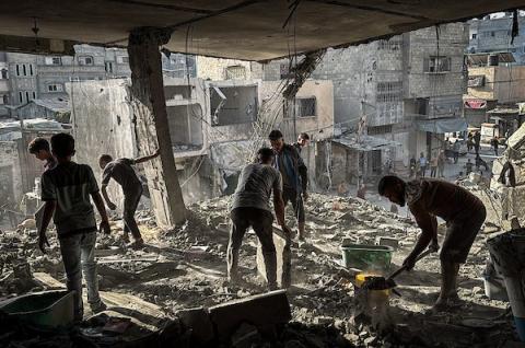 فلسطينيون يتفقدون ممتلكاتهم وسط الأنقاض عقب غارة جوية إسرائيلية استهدفت مبنى سكنياً في مخيم المغازي للاجئين وسط قطاع غزة، في 16 أكتوبر/تشرين الأول 2026. صورة: أحمد إبراهيم