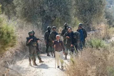 أجبر جنود فلسطينيين على مغادرة بساتين زيتون يملكونها خلال موسم الحصاد في قرية بيتا قرب نابلس. (صورة رويترز)