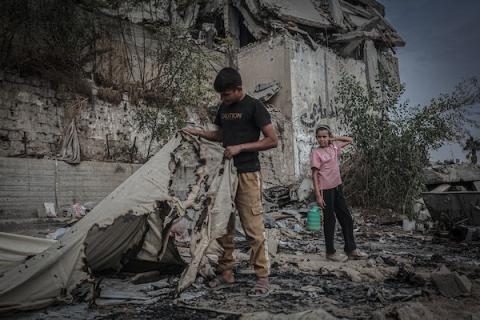 نازحون فلسطينيون يتفقدون بقايا خيامهم وممتلكاتهم التي أتت عليها النيران إثر غارة إسرائيلية قرب مفترق الشجاعية شرقي مدينة غزة، 26 أكتوبر 2026. (تصوير: بلال أسامة)