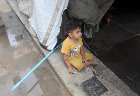 تحت أمطار غزة، يسير فلسطينيون نازحون وسط ظروف معيشية قاسية، فيما يحاول آخرون تغطية خيامهم لمنع تسرب مياه الأمطار إليها، في 18 أكتوبر/تشرين الأول 2026.تصوير: محمد صالحة
