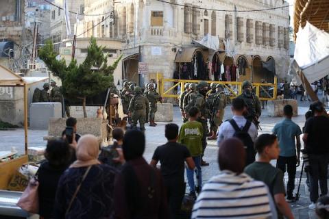 مستوطنون يدخلون البلدة القديمة بمدينة الخليل، جنوبي الضفة الغربية، تحت حماية جنود الاحتلال الإسرائيلي، في 10 أكتوبر/تشرين الأول 2026. (تصوير: مأمون وزواز)