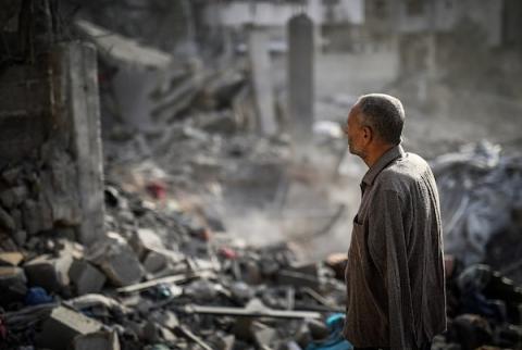 فلسطينيون يتفقدون ممتلكاتهم وسط أنقاض مبنى سكني استهدفته غارة جوية إسرائيلية في حي اليرموك بمدينة غزة، يوم 16 أكتوبر/تشرين الأول 2026. (تصوير: محمد صالحة)