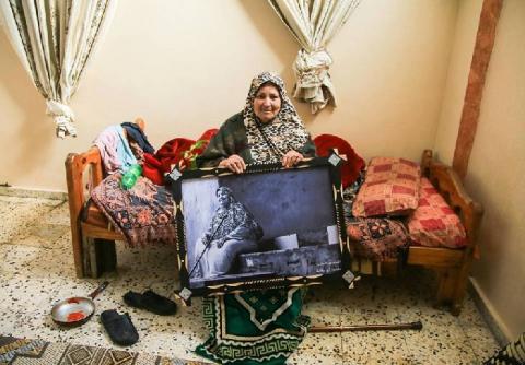 مصور يفاجئ أهالي مخيم جباليا بإهدائهم صوراً مؤطرة من أرشيفه