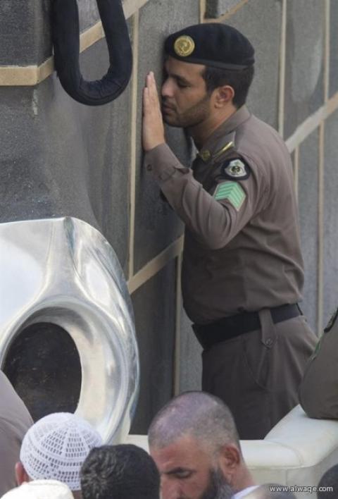 صورة مؤثرة لرجل أمن يلتزم الكعبة في حالة خشوع تام