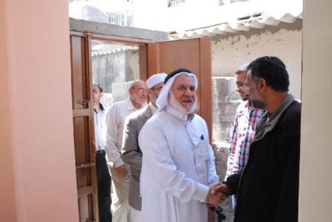 لجنة الترميم بدير البلح تسلم منزل المواطن جميل دواس
