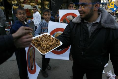 فلسطينيون يوزعون الحلوى في غزة ابتهاجا بموت شارون/عدسة: عبد الرحيم الخطيب