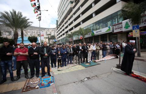مواطنون يؤدون صلاة الجمعة في ميدان الشهداء وسط نابلس تضامناً مع الأسرى في سجون الإحتلال تصوير: ايمن نوباني