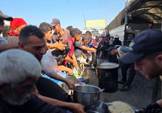 نازحون فلسطينيون يتلقون مساعدات غذائية من مطبخ خيري في مواصي خان يونس، جنوب قطاع غزة، 23 أكتوبر 2026. (تصوير: طارق محمد)