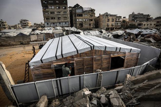 الفلسطيني هشام حميد يبني مأوى لعائلته من أخشاب المساعدات والطين قرب أنقاض منزله غرب مدينة غزة، استعدادًا لبرد الشتاء، 28 أكتوبر/تشرين الأول 2026. (تصوير: محمد صالحة)