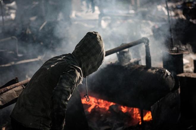 عمال فلسطينيون يجمعون ويفرزون النفايات البلاستيكية لإنتاج وقود بديل باستخدام أفران بدائية، في حي الشيخ رضوان شمال مدينة غزة، لمواجهة شح المحروقات الناجم عن الحصار الإسرائيلي، 29 أكتوبر 2026. (تصوير: محمد صالحة)