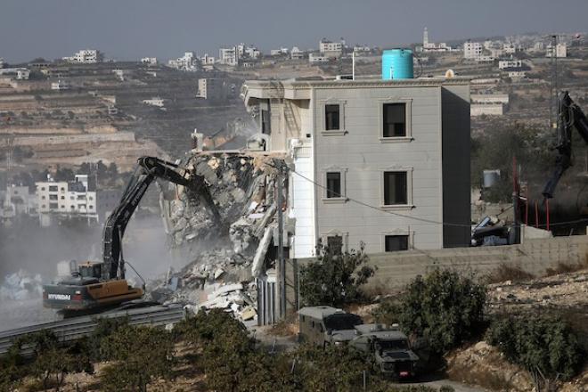 آليات الاحتلال الإسرائيلي تهدم منزلاً فلسطينياً في الخليل، وسط انتشار عسكري مكثف عقب استشهاد فلسطينيين اثنين، 23 أكتوبر 2026. (تصوير: مأمون وزواز)