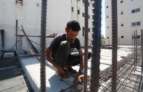 اللاجئ الفلسطيني كمال أبو غبن يعزف على آلة العود أثناء راحته في العمل 10