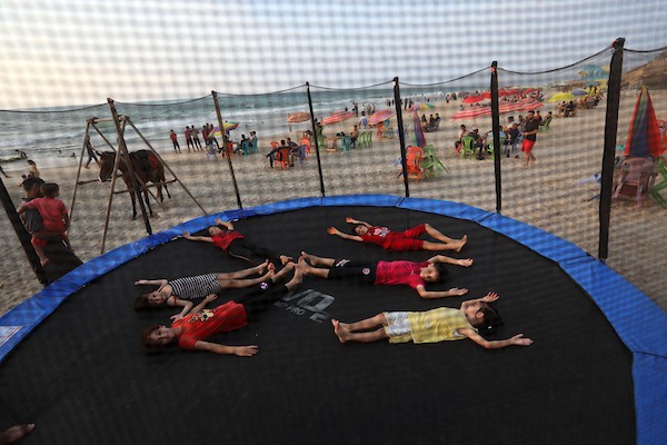 فلسطينيون يستمتعون بأوقاتهم على شاطئ البحر في مدينة دير البلح وسط قطاع غزة. 21