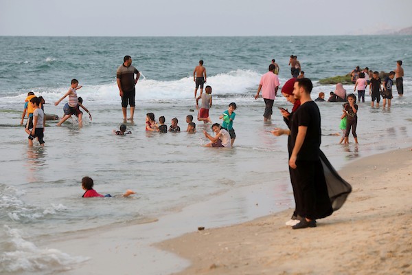 فلسطينيون يستمتعون بأوقاتهم على شاطئ البحر في مدينة دير البلح وسط قطاع غزة. 36