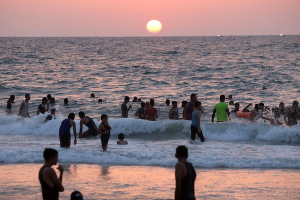 فلسطينيون يستمتعون بأوقاتهم على شاطئ البحر في مدينة دير البلح وسط قطاع غزة. 28