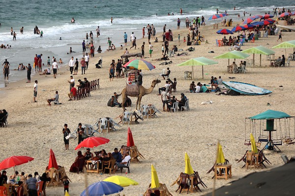 فلسطينيون يستمتعون بأوقاتهم على شاطئ البحر في مدينة دير البلح وسط قطاع غزة. 15