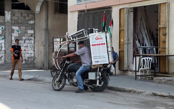 الفلسطيني داود البوجي (46 عاما) من غزة يبيع المعجنات باستخدام مخبز متنقل يسمى الست بنات ، في شوارع مخيم الشاطئ غرب مدينة غزة  1