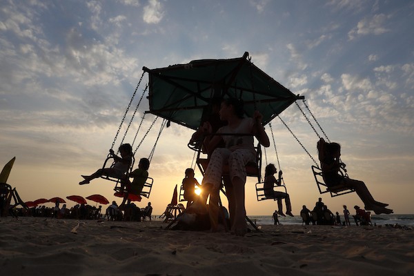 فلسطينيون يستمتعون بأوقاتهم على شاطئ البحر في مدينة دير البلح وسط قطاع غزة. 37