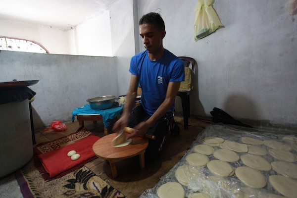 الشاب الفلسطيني أحمد علي ، 31 عامًا ، يصنع فطير مشلتت ، في متجره في مخيم الشاطئ ، في مدينة غزة 11.JPG
