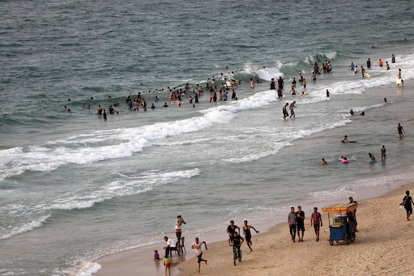 فلسطينيون يستمتعون بأوقاتهم على شاطئ البحر في مدينة دير البلح وسط قطاع غزة. 18