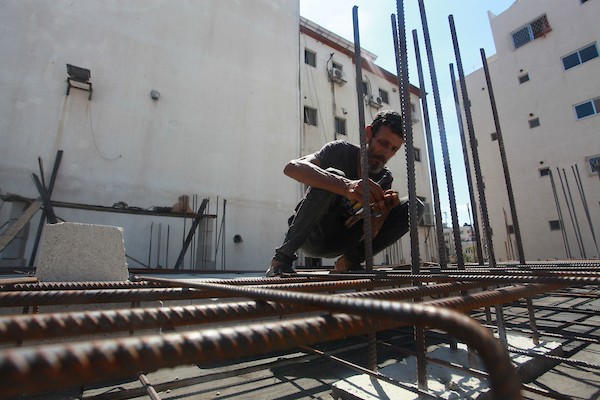 اللاجئ الفلسطيني كمال أبو غبن يعزف على آلة العود أثناء راحته في العمل 13