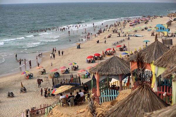 فلسطينيون يستمتعون بأوقاتهم على شاطئ البحر في مدينة دير البلح وسط قطاع غزة.9