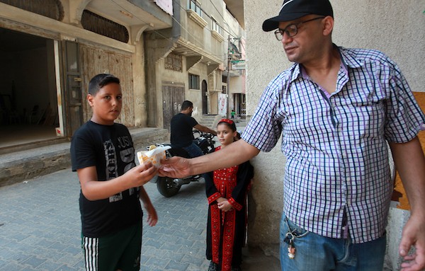 الفلسطيني داود البوجي (46 عاما) من غزة يبيع المعجنات باستخدام مخبز متنقل يسمى الست بنات ، في شوارع مخيم الشاطئ غرب مدينة غزة  14