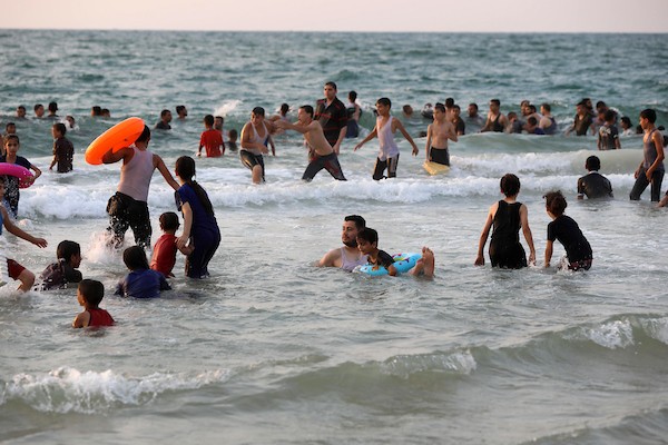 فلسطينيون يستمتعون بأوقاتهم على شاطئ البحر في مدينة دير البلح وسط قطاع غزة.1