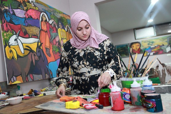 أقام الفنانان التشكيليان الفلسطينيان محمد الحواجري وزوجته دينا مطر معرضا للوحاتهما على سطح منزلهما في مخيم البريج وسط قطاع غزة  2