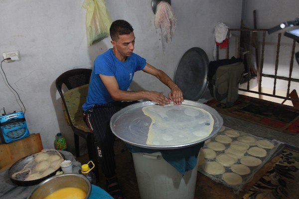 الشاب الفلسطيني أحمد علي ، 31 عامًا ، يصنع فطير مشلتت ، في متجره في مخيم الشاطئ ، في مدينة غزة  6.JPG