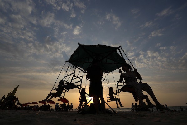 فلسطينيون يستمتعون بأوقاتهم على شاطئ البحر في مدينة دير البلح وسط قطاع غزة. 48