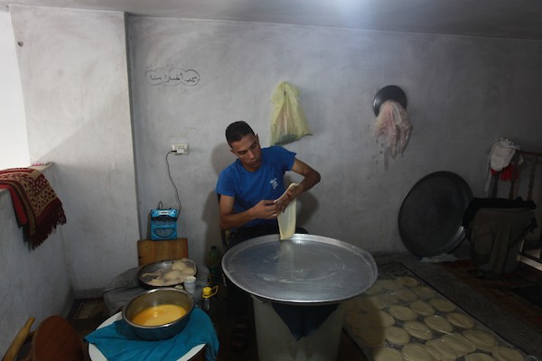 الشاب الفلسطيني أحمد علي ، 31 عامًا ، يصنع فطير مشلتت ، في متجره في مخيم الشاطئ ، في مدينة غزة  5.JPG