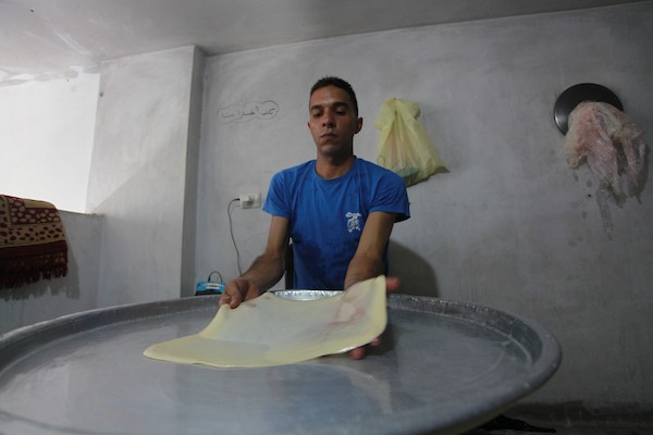 الشاب الفلسطيني أحمد علي ، 31 عامًا ، يصنع فطير مشلتت ، في متجره في مخيم الشاطئ ، في مدينة غزة  23.JPG