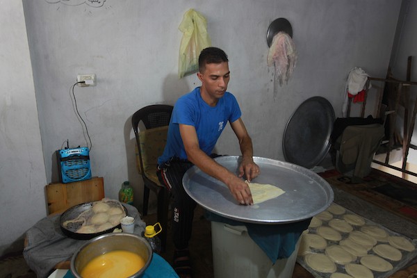 الشاب الفلسطيني أحمد علي ، 31 عامًا ، يصنع فطير مشلتت ، في متجره في مخيم الشاطئ ، في مدينة غزة  8.JPG