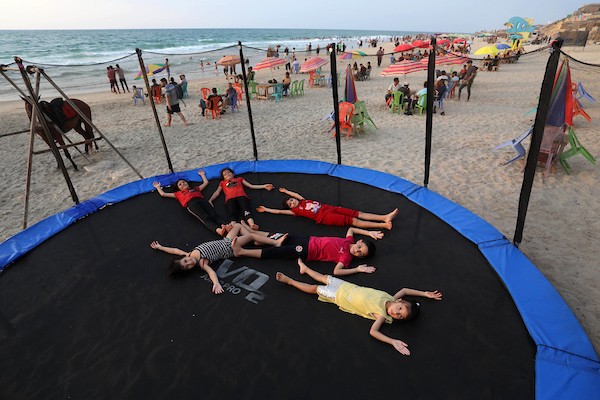 فلسطينيون يستمتعون بأوقاتهم على شاطئ البحر في مدينة دير البلح وسط قطاع غزة. 31