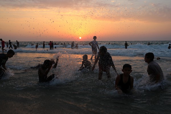 فلسطينيون يستمتعون بأوقاتهم على شاطئ البحر في مدينة دير البلح وسط قطاع غزة. 6
