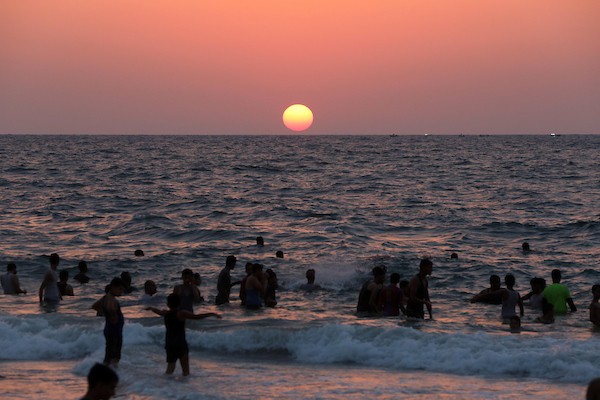 فلسطينيون يستمتعون بأوقاتهم على شاطئ البحر في مدينة دير البلح وسط قطاع غزة. 7